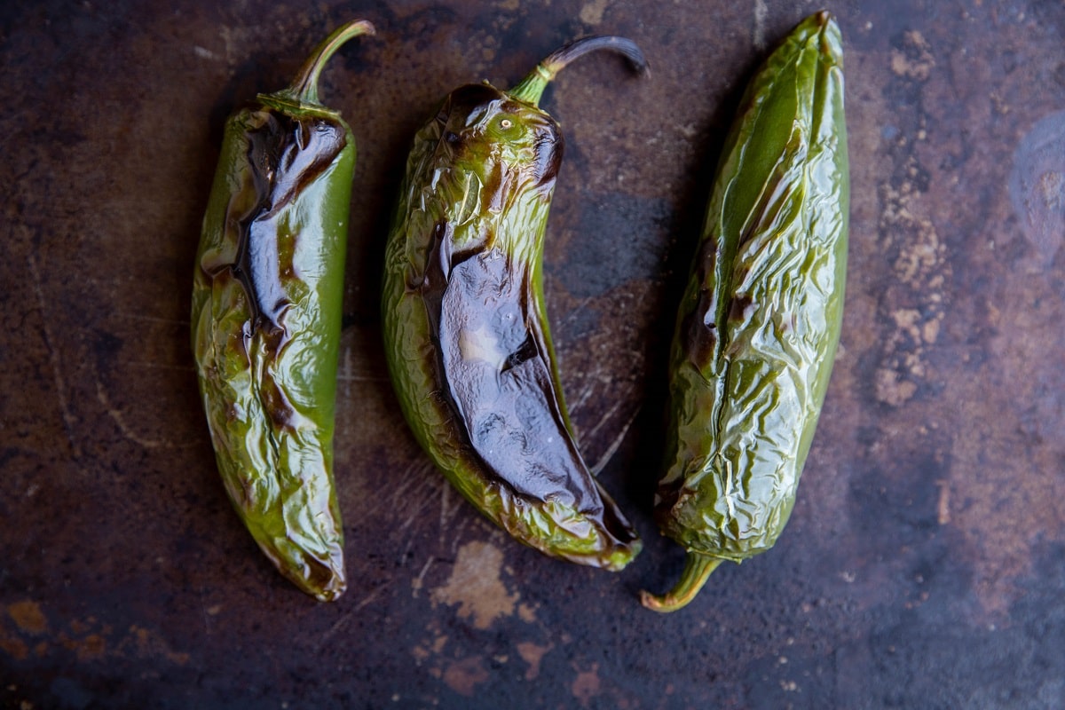 Roasted jalapenos on a baking sheet.