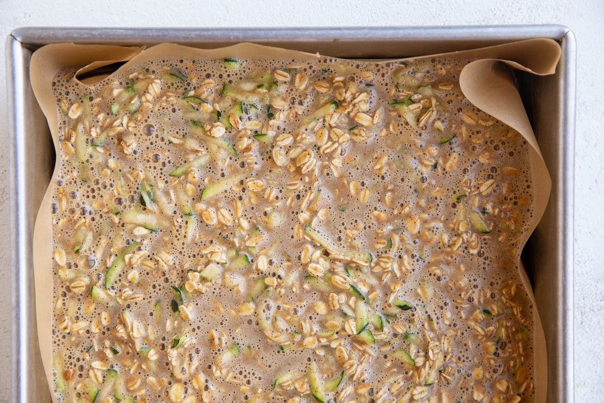 Zucchini oatmeal mixture in a baking pan, ready to be baked.