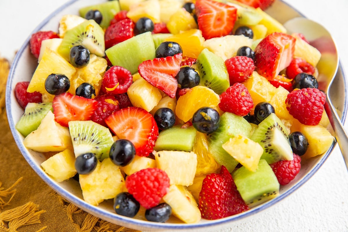 Blue rimmed bowl of fresh fruit salad.