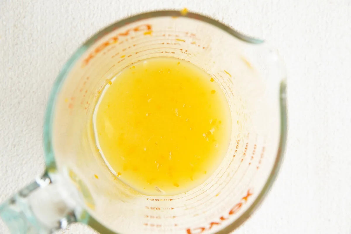 Citrus dressing for fruit salad in a measuring cup.