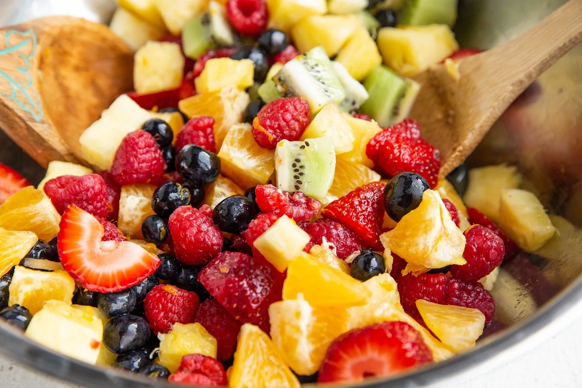 Mixing bowl full of fruit salad, recently tossed in dressing and ready to serve.