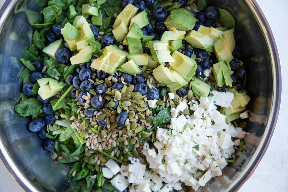 Salad ingredients in a large mixing bowl, ready to be tossed with salad dressing.