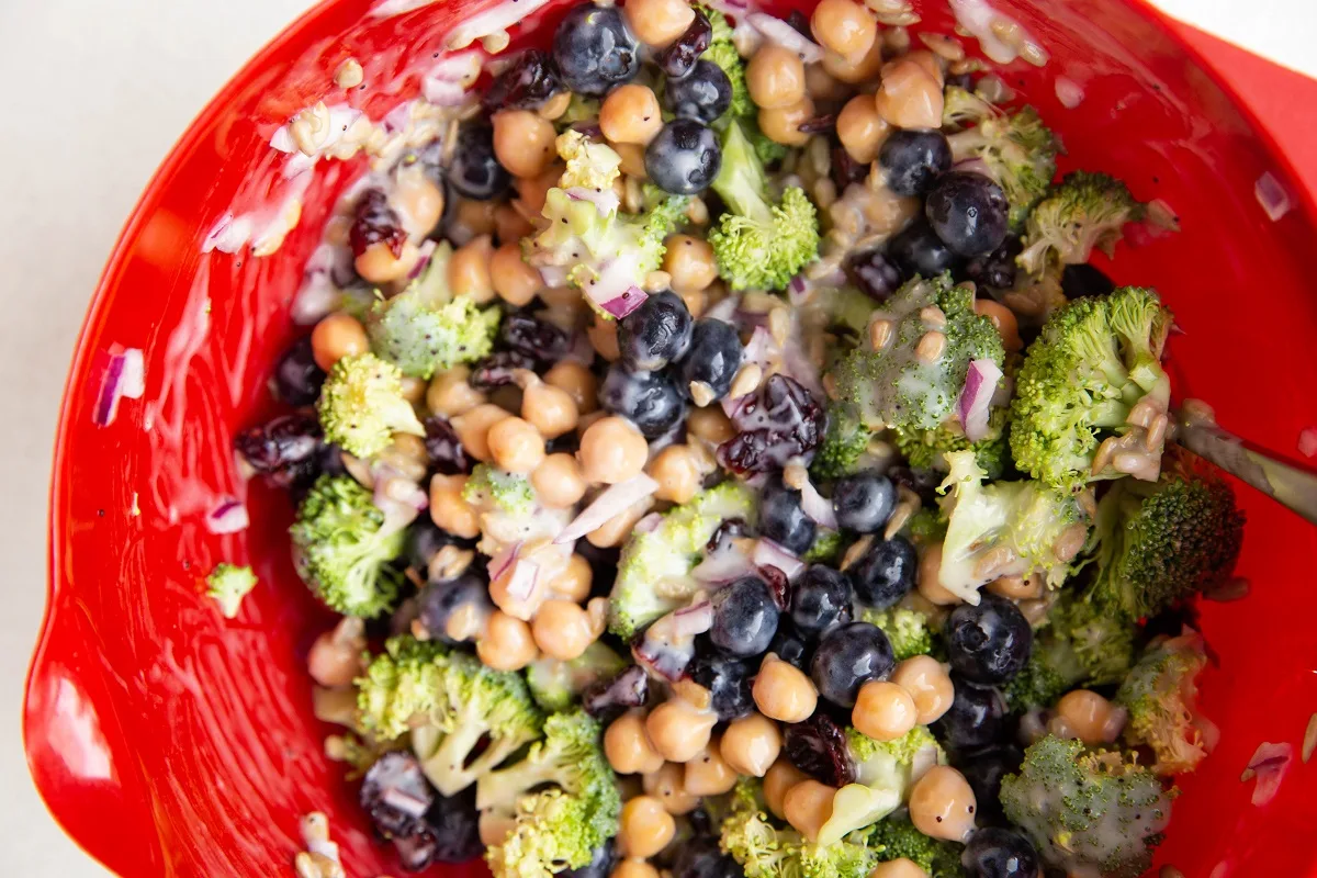 Broccoli chickpea salad mixed up in a mixing bowl, ready to serve.