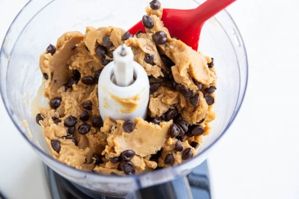 Rubber spatula stirring the chocolate chips into the edible cookie dough.