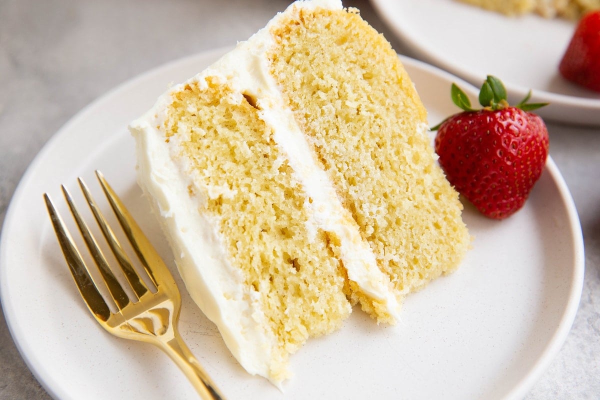 Close up of a thick slice of vanilla cake with vanilla frosting.