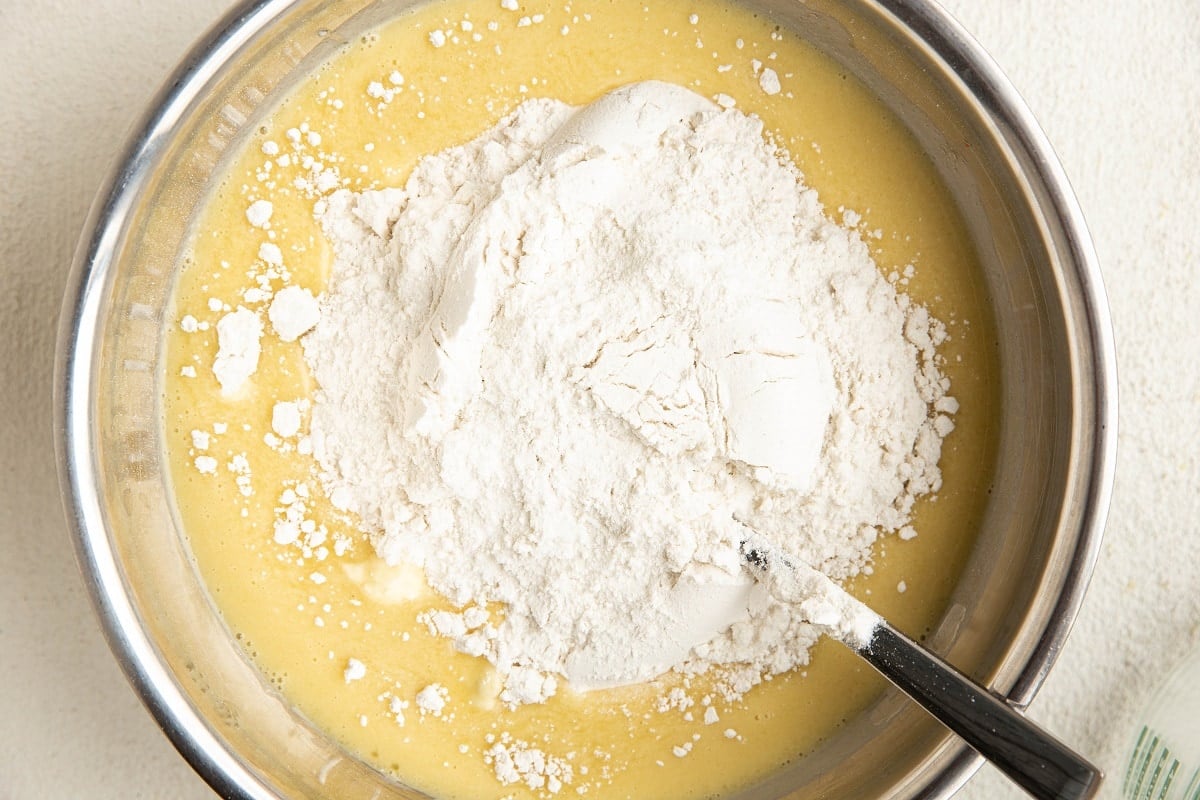 Wet ingredients with dry ingredients on top in a mixing bowl.