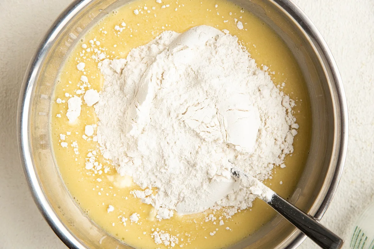 Wet ingredients with dry ingredients on top in a mixing bowl.