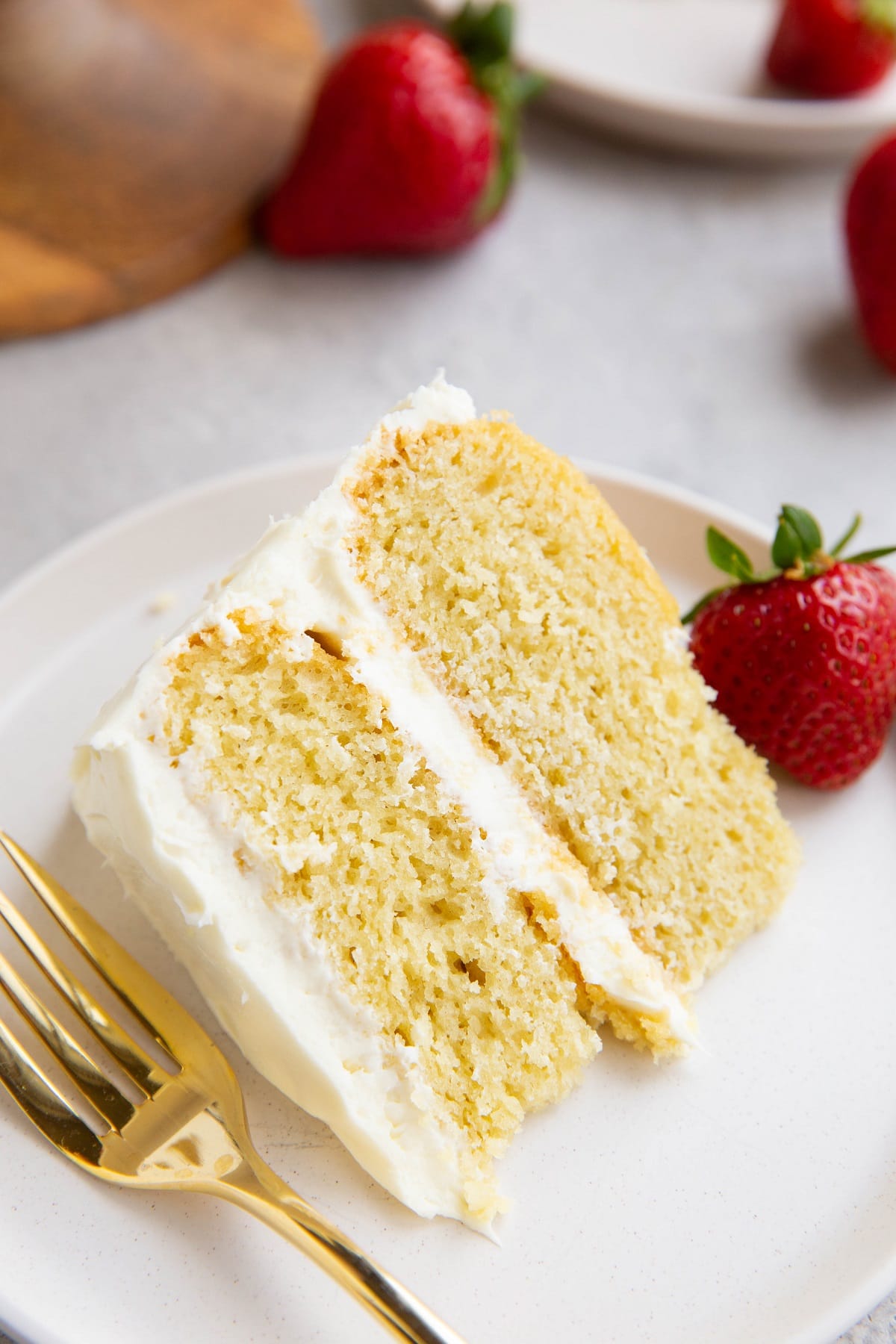 Thick slice of a vanilla layer cake on a white plate.