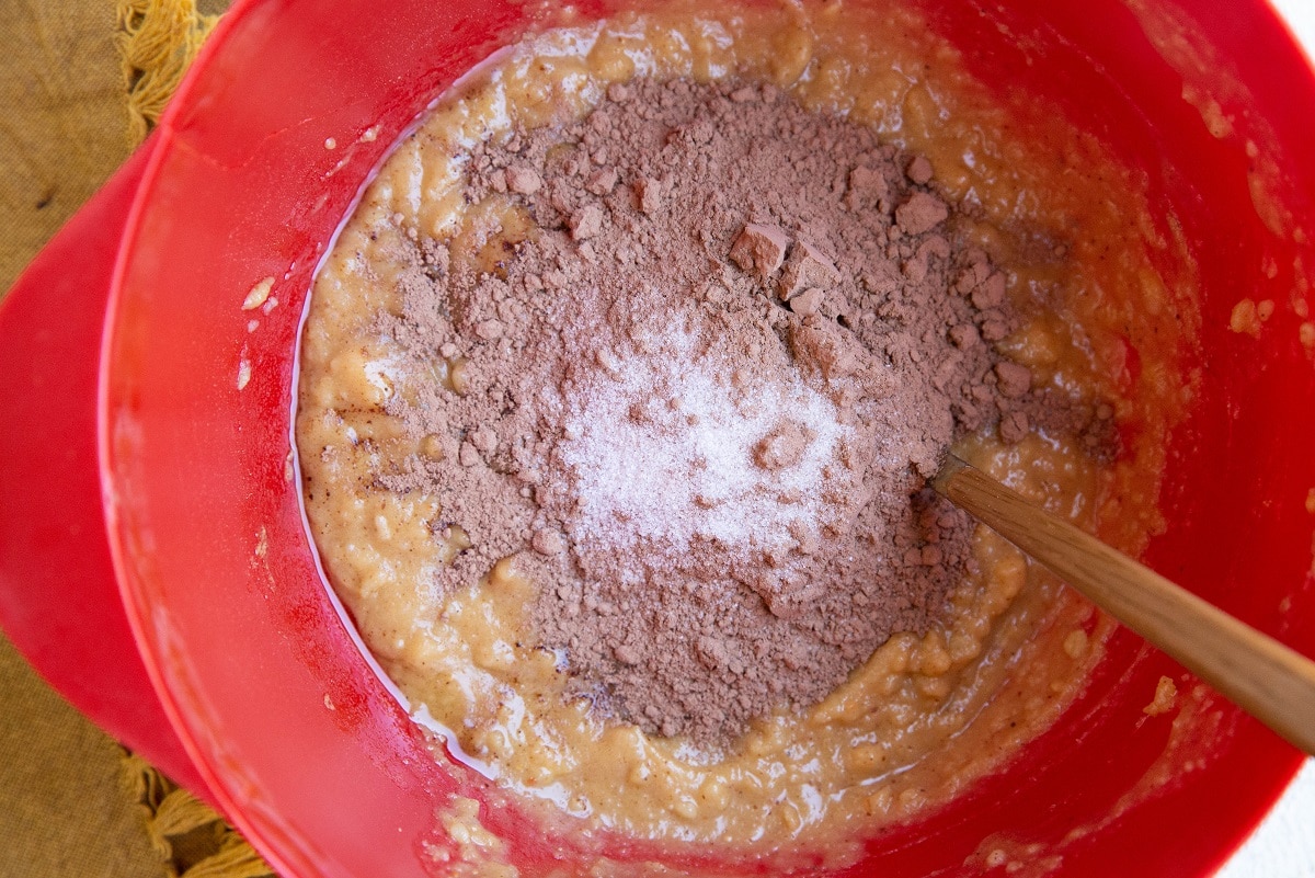 Wet ingredients for zucchini brownies with the dry ingredients on top.