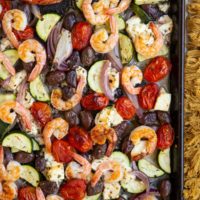 Large baking sheet with shrimp and vegetables for a complete meal, fresh out of the oven.