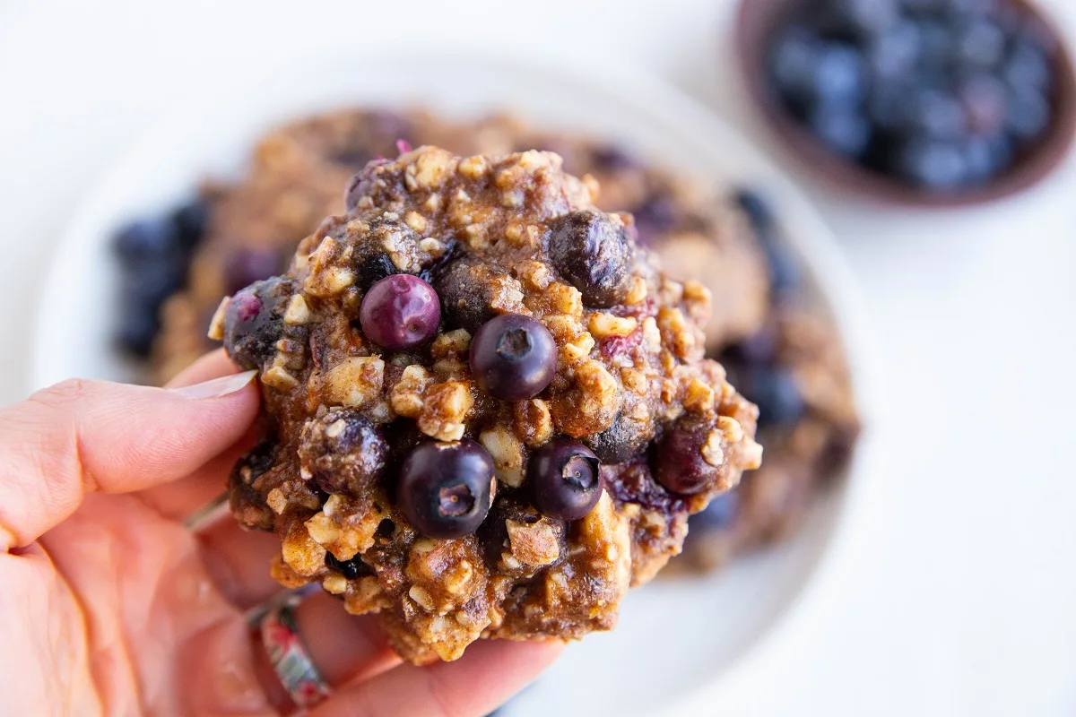 Hand holding one blueberry banana nut cookie.