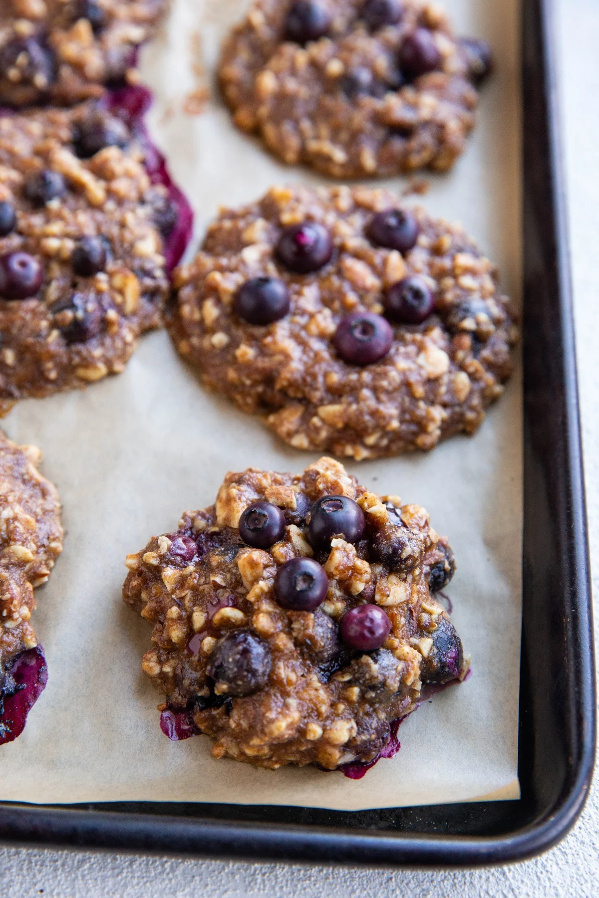 Nutty Banana Blueberry cookies on a large baking sheet, fresh out of the oven.