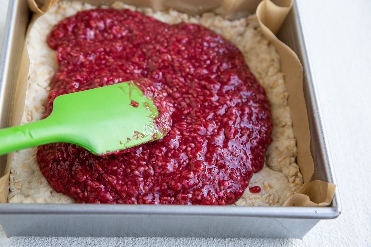 Raspberry filling on top of a shortbread crust to make raspberry crumb bars