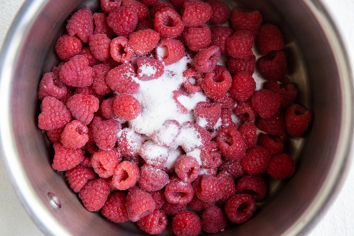 Raspberries and sugar in a pot.