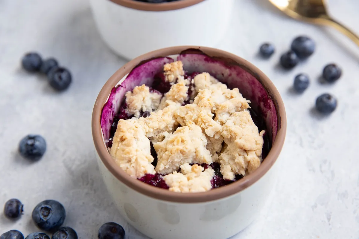 Single serve blueberry cobbler in a ramekin, fresh out of the oven.