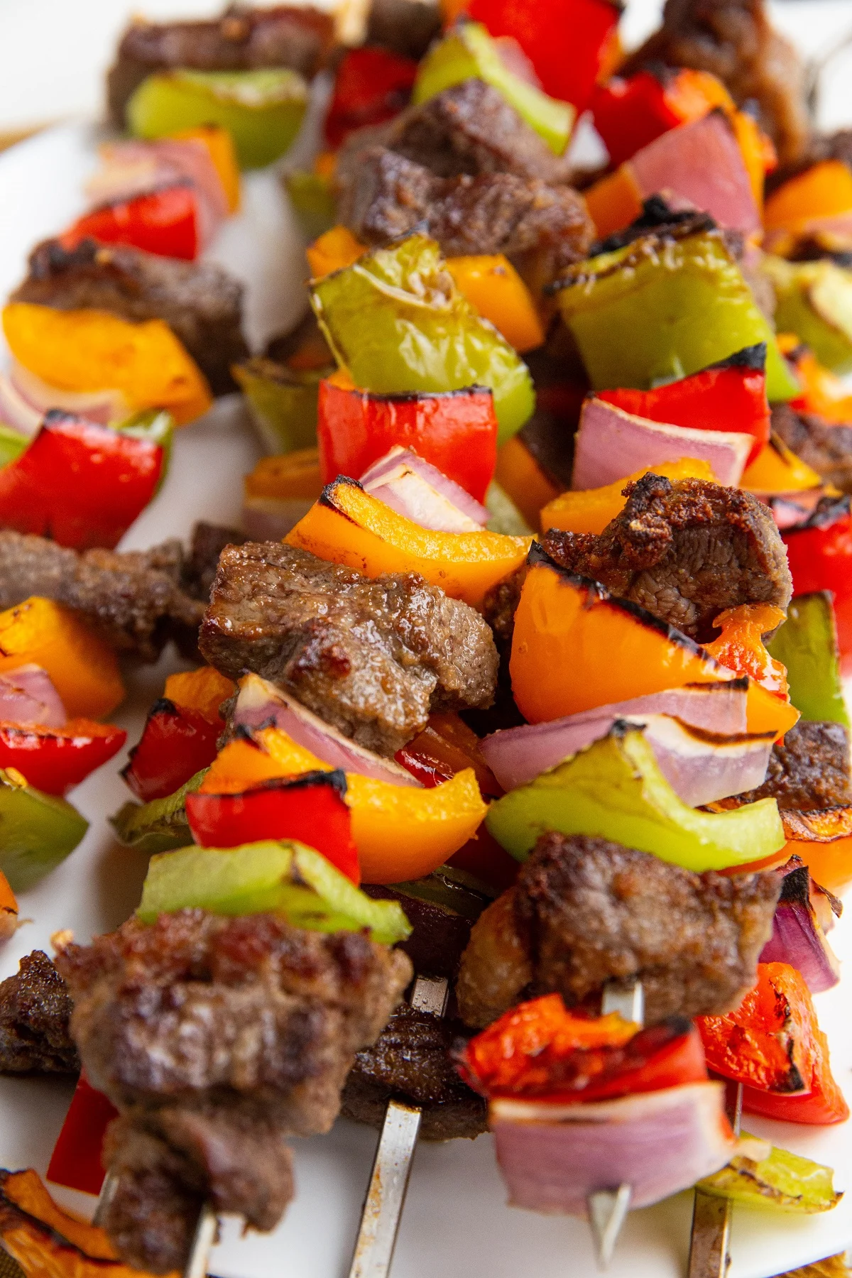Plate of beef kabobs stacked on top of each other, fresh off the grill.