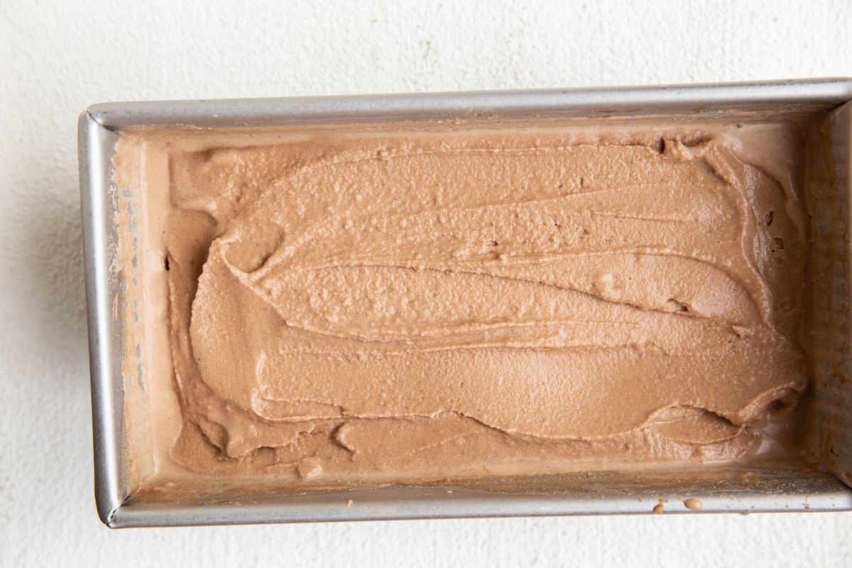 Soft chocolate ice cream in a loaf pan, ready to go into the freezer.