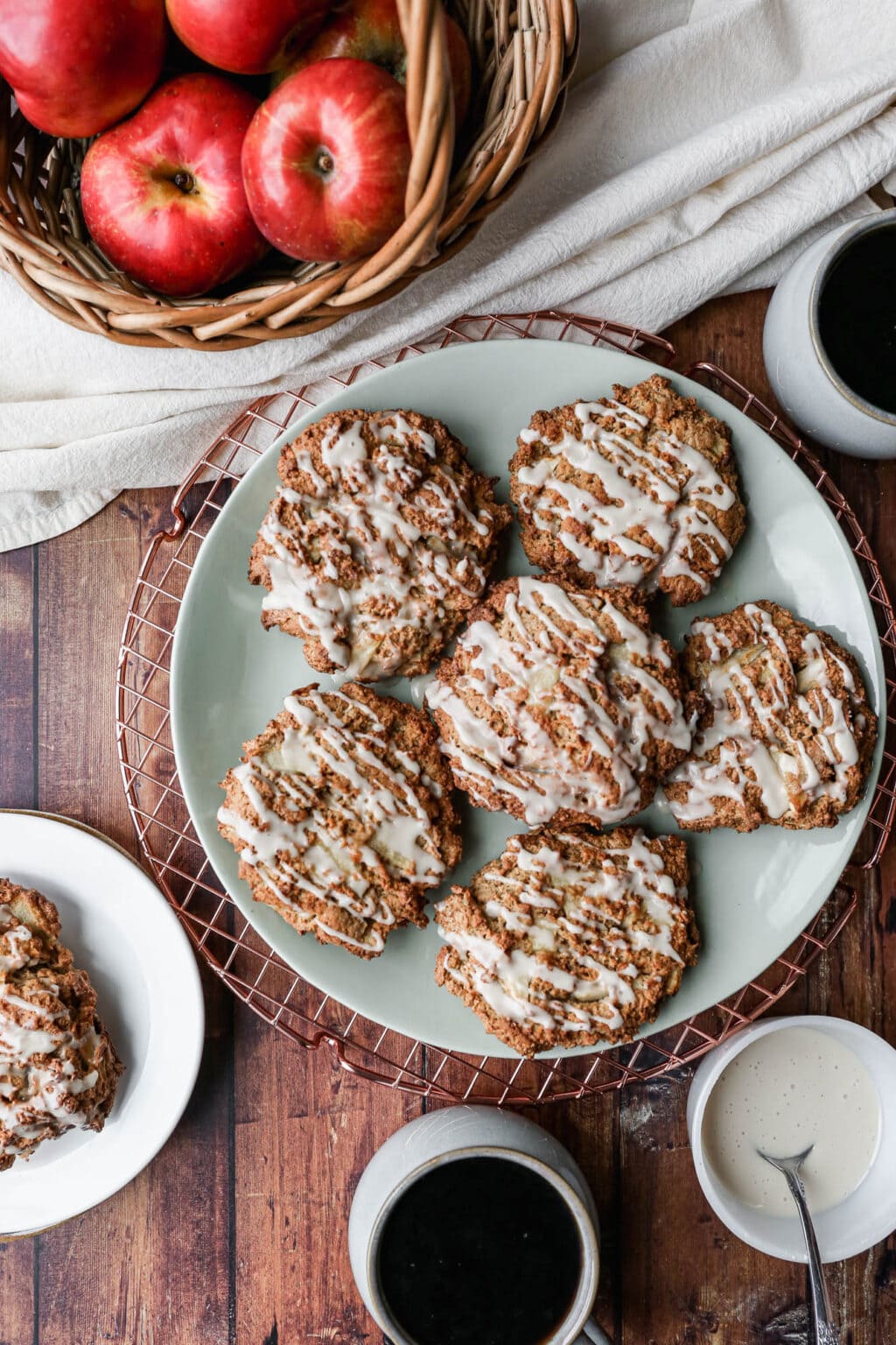 Apple fritters on a plate with fresh apples to the side.