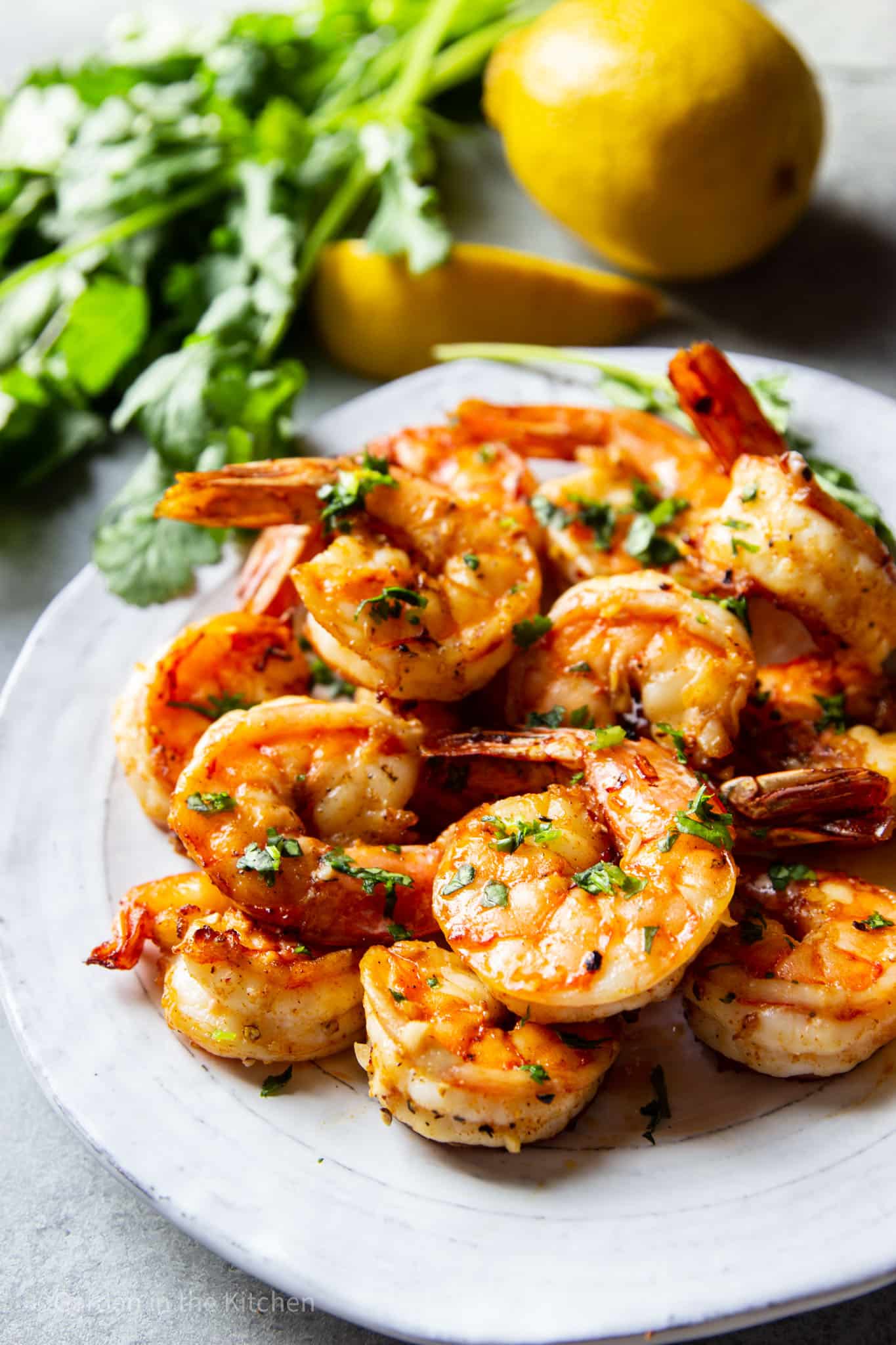 Shrimp on a plate with fresh lemon in the background.