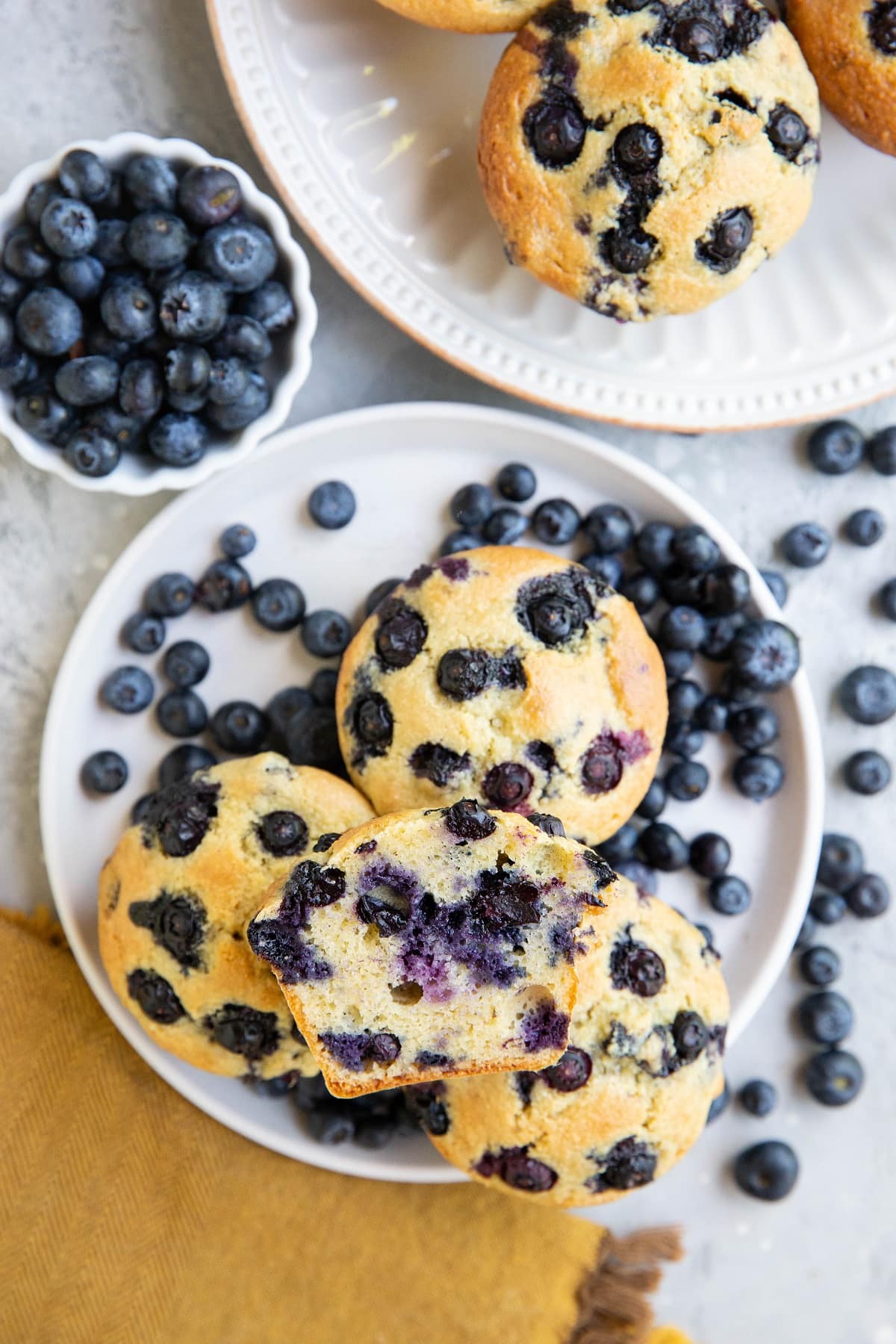 Two white plates of blueberry muffins