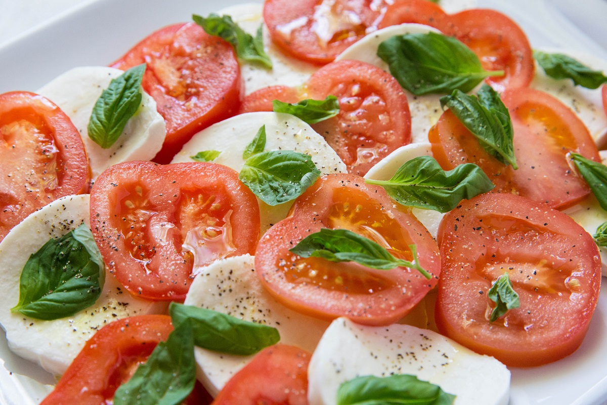 Layers of tomatoes and mozzarella on a serving dish.