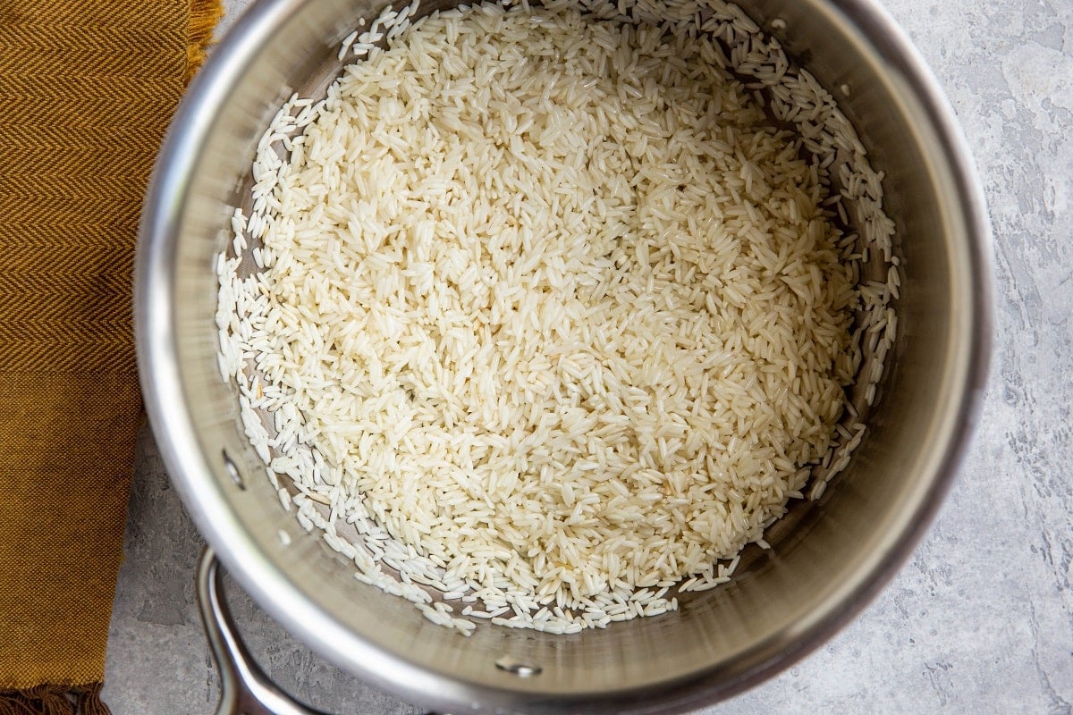 White rice in a medium saucepan, sautéing to brown.