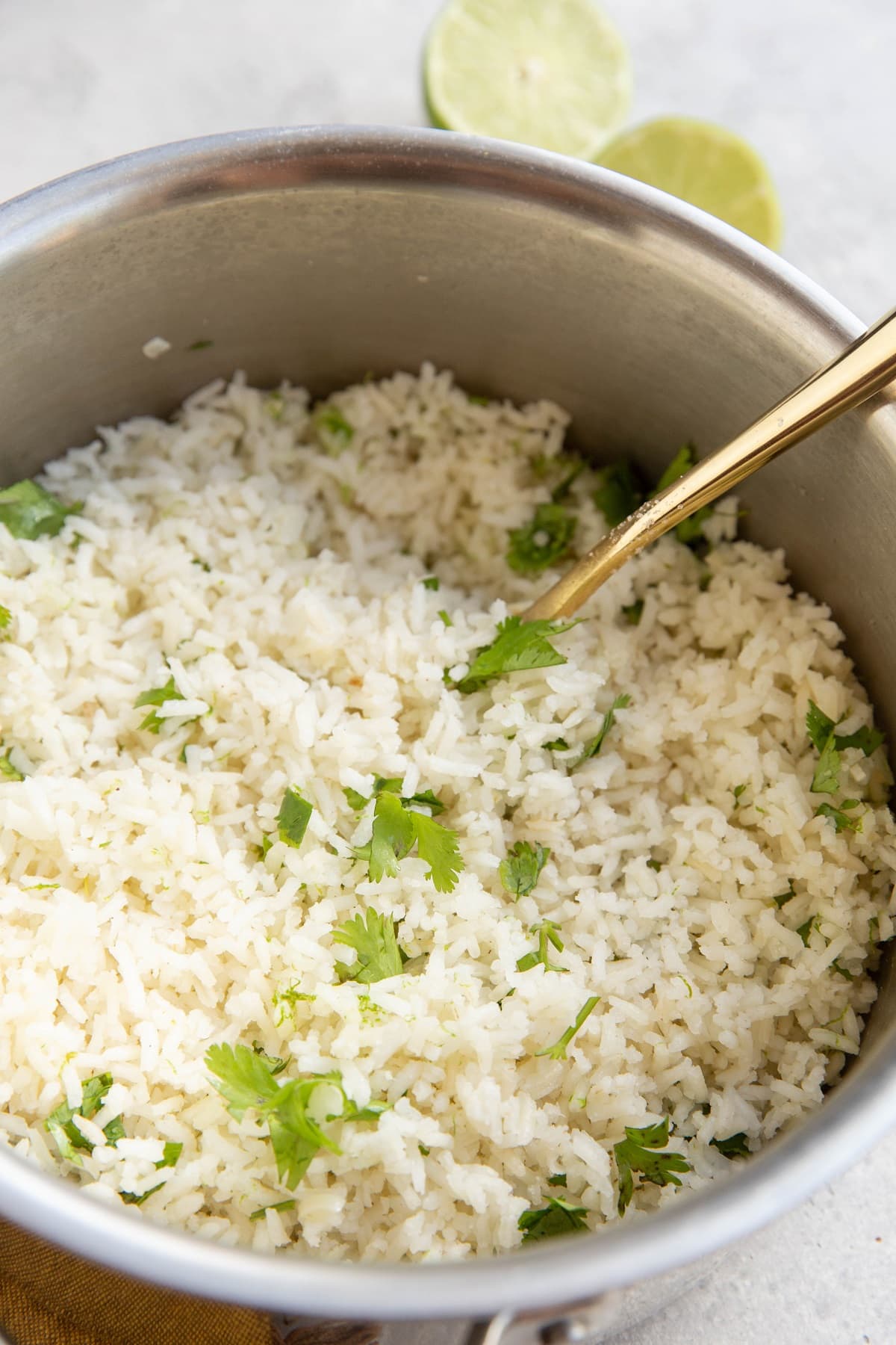 Cilantro Lime rice in a stainless steel pot with a golden fork, ready to serve.