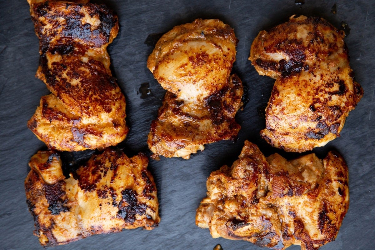 Cooked chicken on a cutting board, resting.