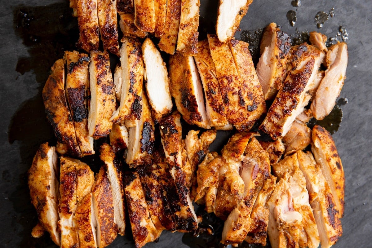 Sliced chicken thighs on a cutting board.