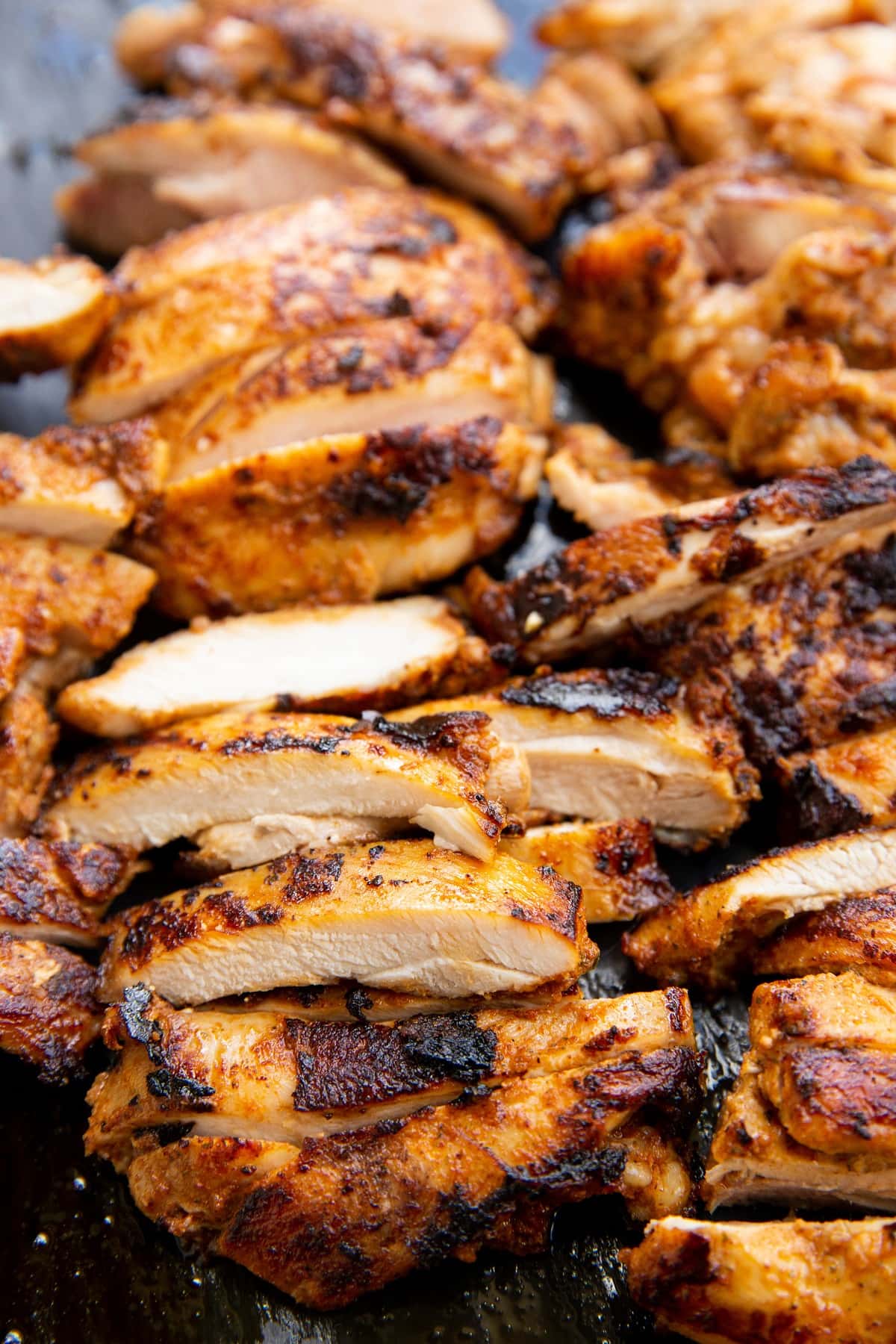 Chicken sliced up on a cutting board.