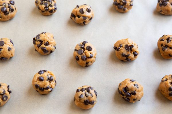 Cookie dough balls on a parchment-lined baking sheet.