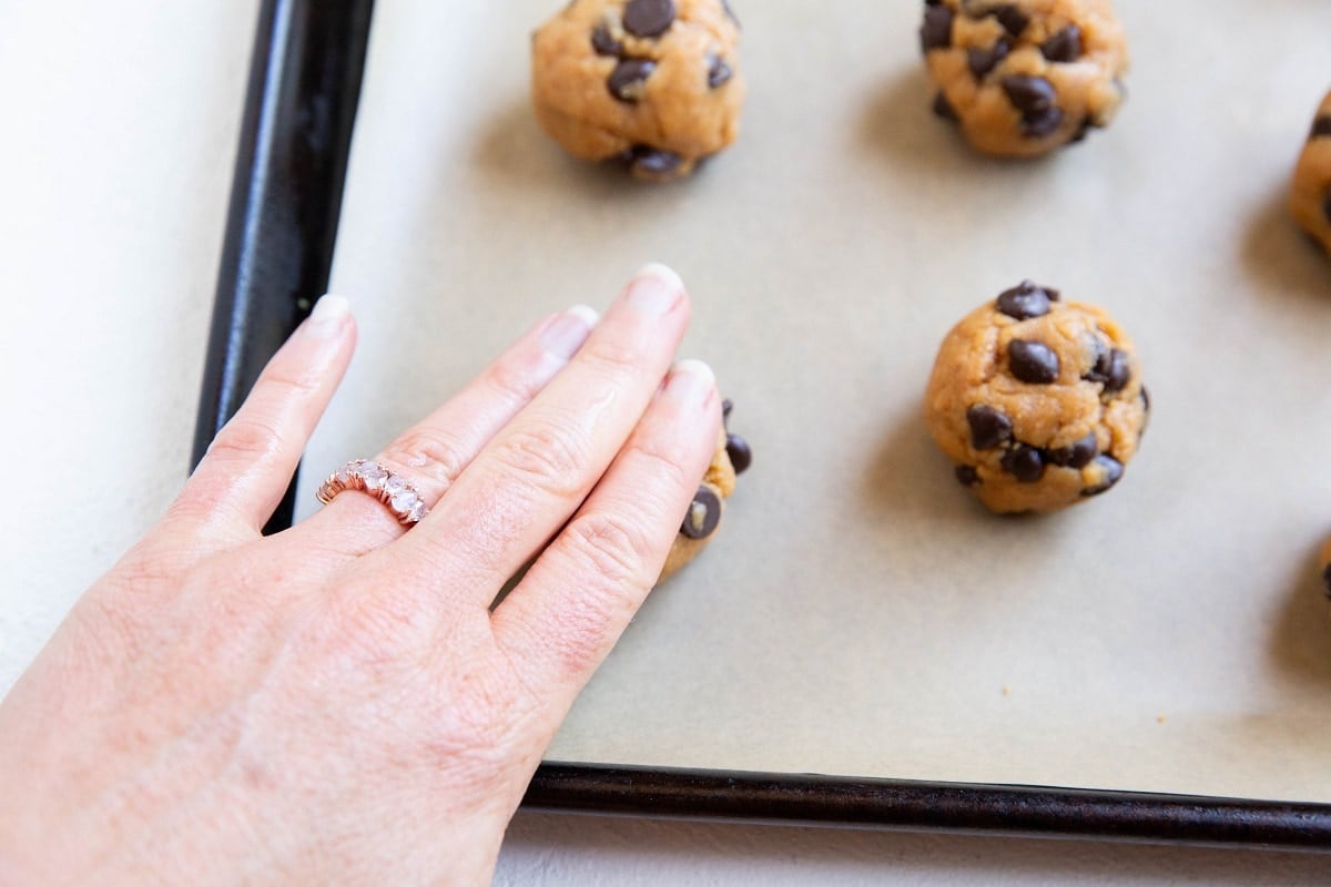 Hand pressing the cookie dough into a disc.