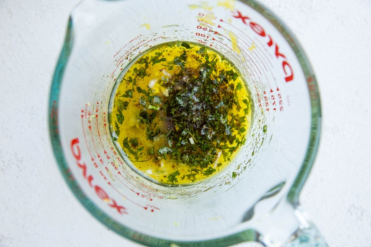 Ingredients for lentil salad dressing in a measuring cup.