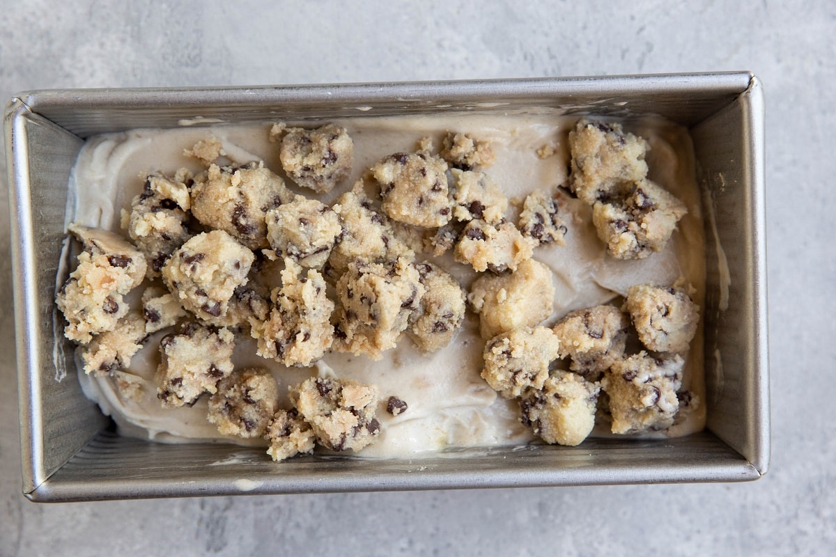 Chunks of cookie dough on top of banana ice cream.