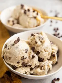 Two white bowls of cookie dough ice cream.