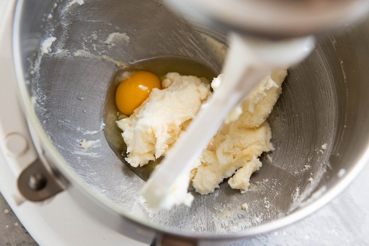 Creamed butter and sugar in an electric mixer with an egg added in to be mixed in.