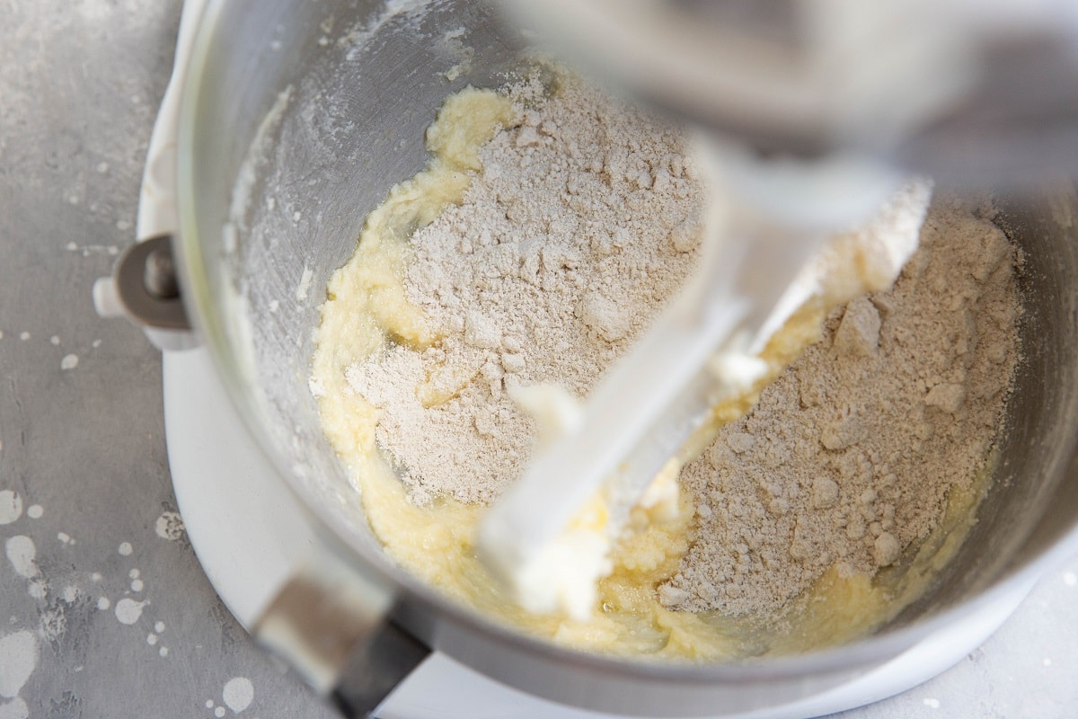 Wet ingredients in a stand mixer with dry ingredients on top, ready to be mixed in.