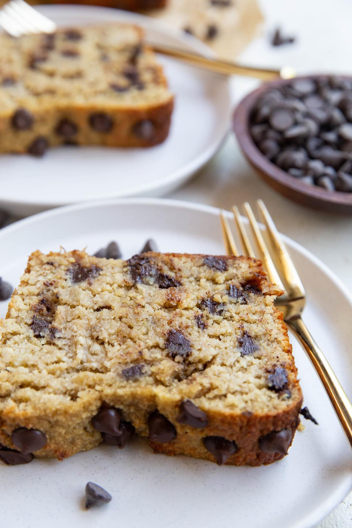 Two slices of banana bread on white plates.