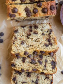 Banana bread sliced on a sheet of parchment paper.