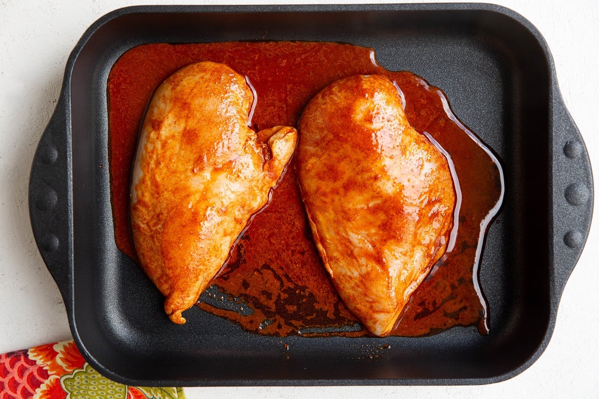 Marinated chicken breasts in a large casserole dish, ready to be baked
