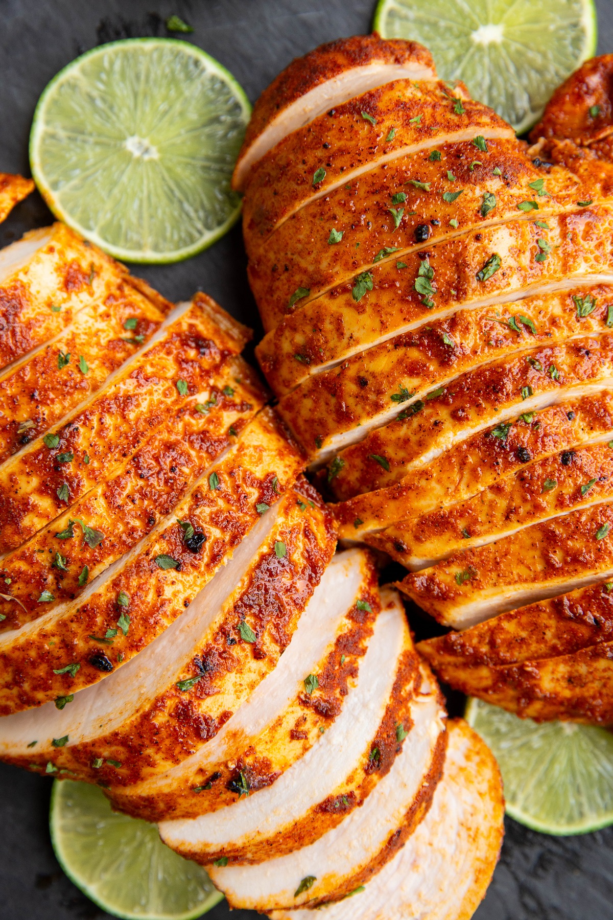 Sliced chili lime chicken breasts on a cutting board.