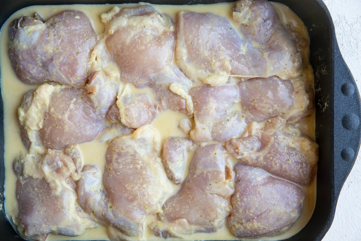 Casserole dish full of chicken and marinade, ready to be baked.
