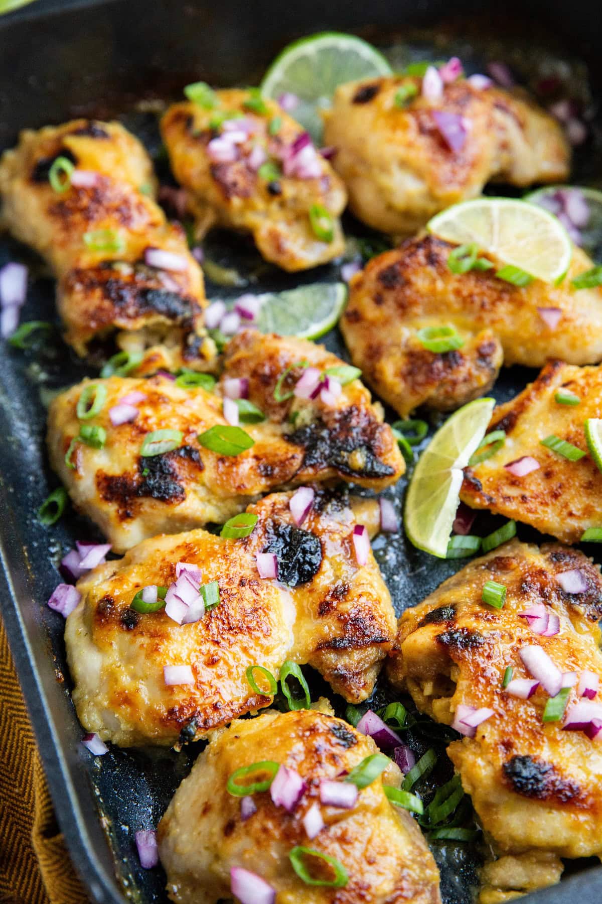 Mojo chicken thighs fresh out of the oven in a large baking dish.