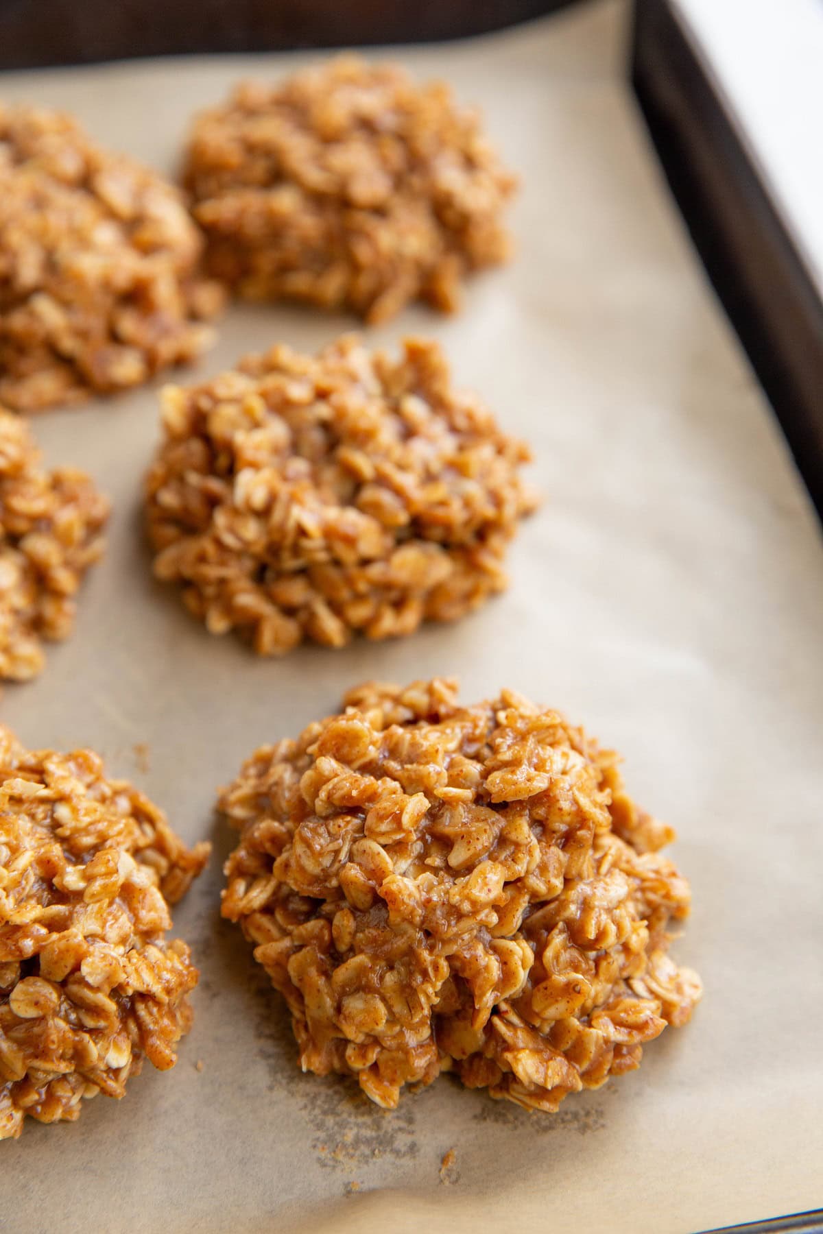 Almond butter oatmeal cookies on a baking sheet, ready to be eaten.