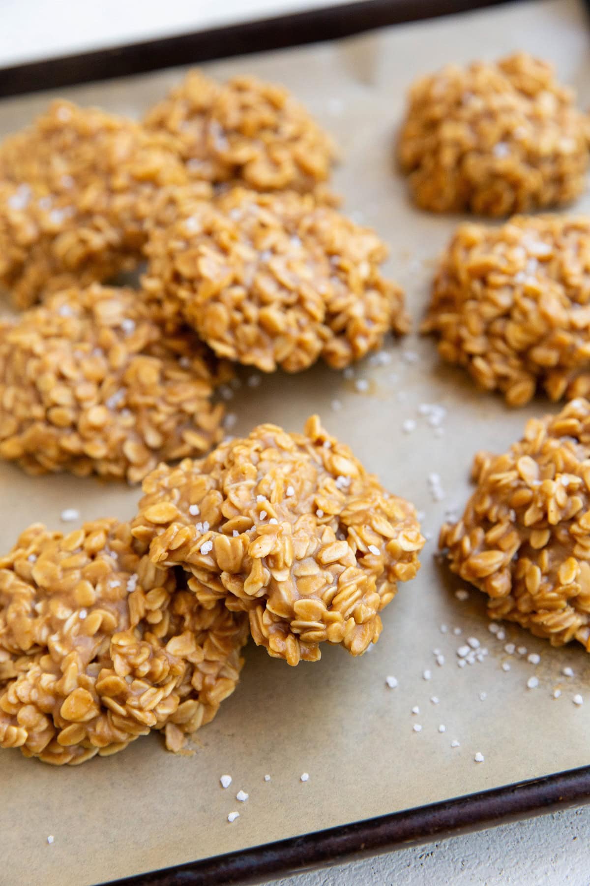 Cookie sheet of peanut butter no-bake cookies sprinkled with sea salt.