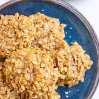 Blue plate with peanut butter oatmeal cookies stacked on it, ready to eat.