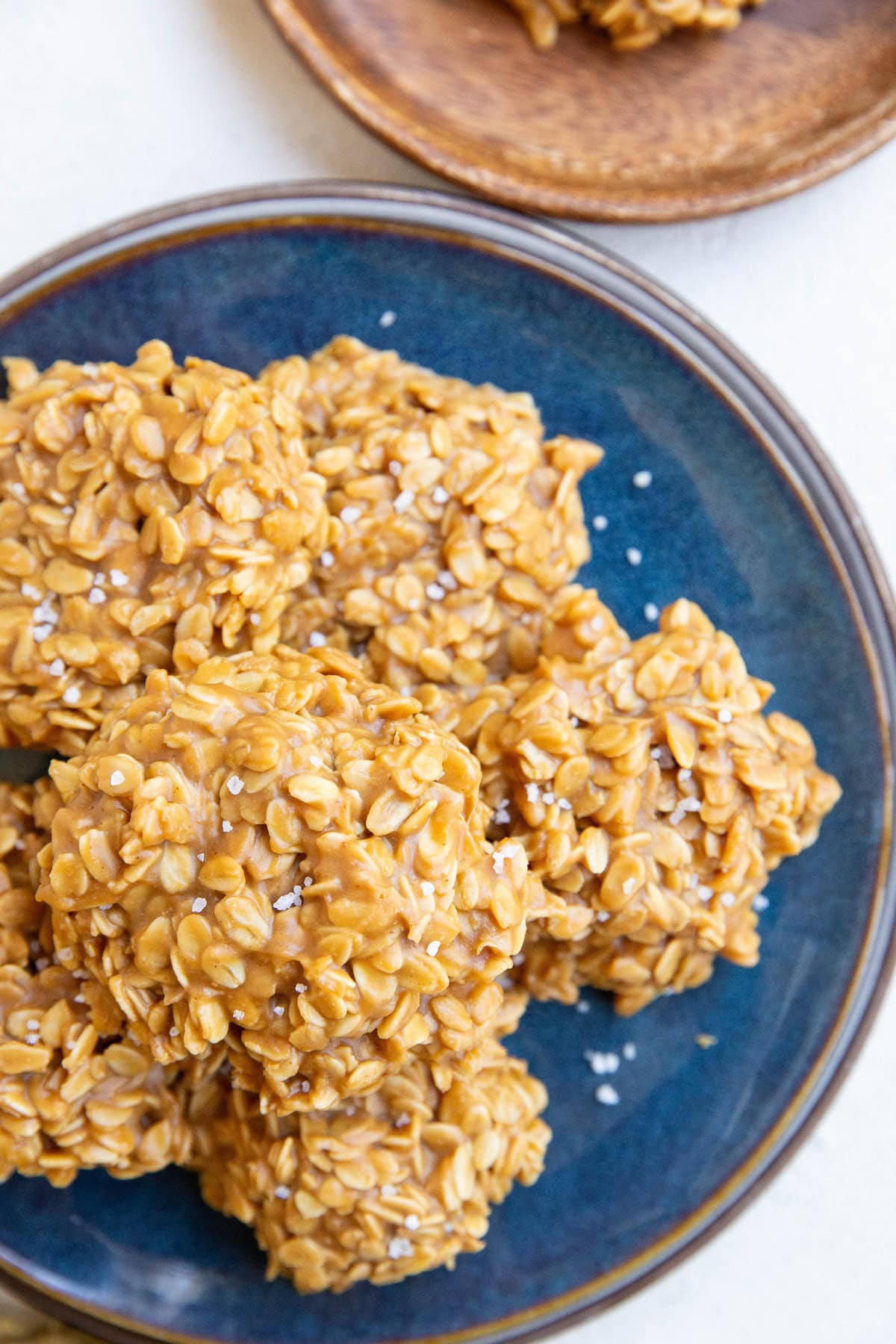 Blue plate with peanut butter oatmeal cookies stacked on it, ready to eat.