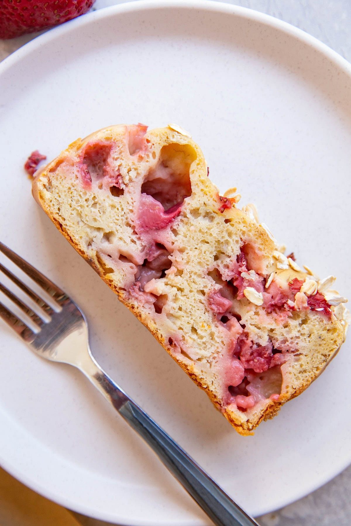 Slice of strawberry banana bread on a white plate.