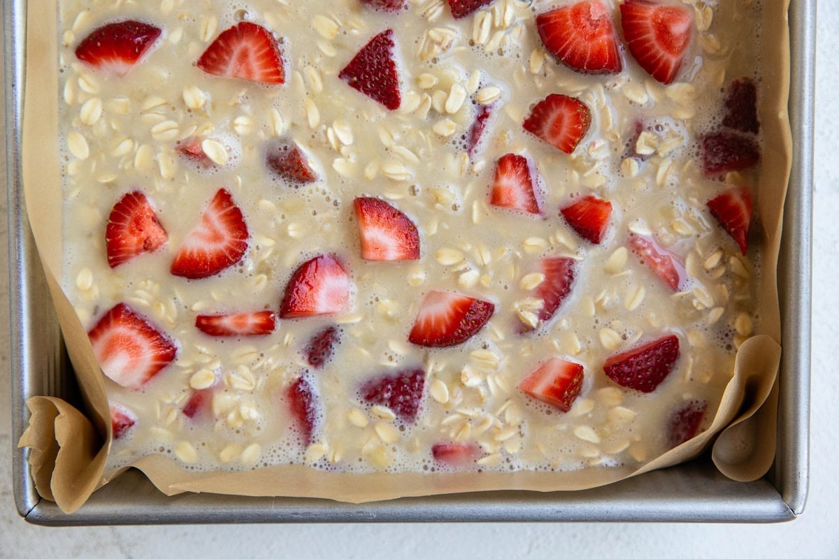 Parchment-lined baking dish with oatmeal mixture.