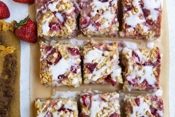 Individual portions of strawberry banana oatmeal cut on a piece of parchment paper.